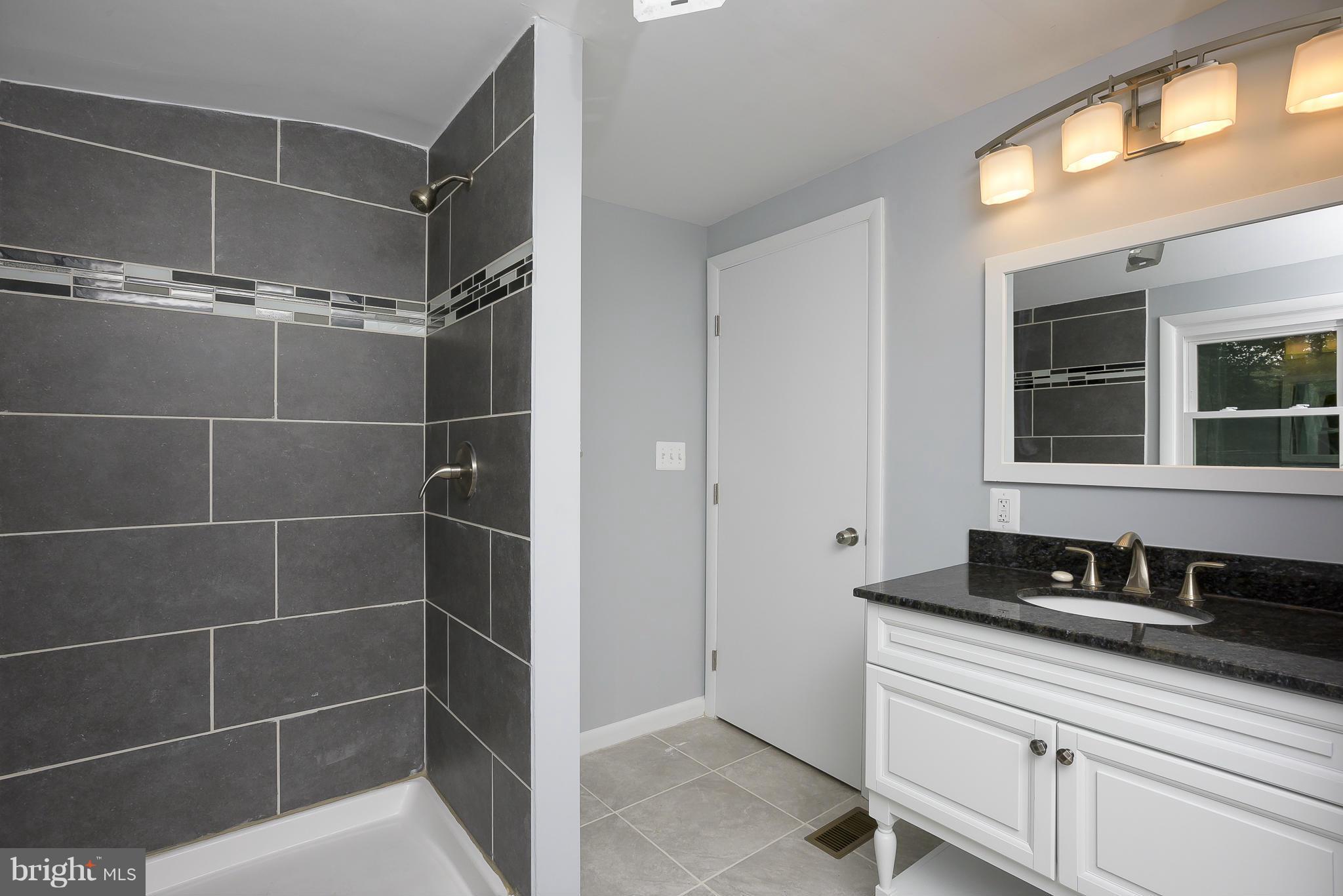 8413 Garland Road Pasadena, MD 21122 - Photo 15 of 30 a bathroom with a double vanity sink and mirror