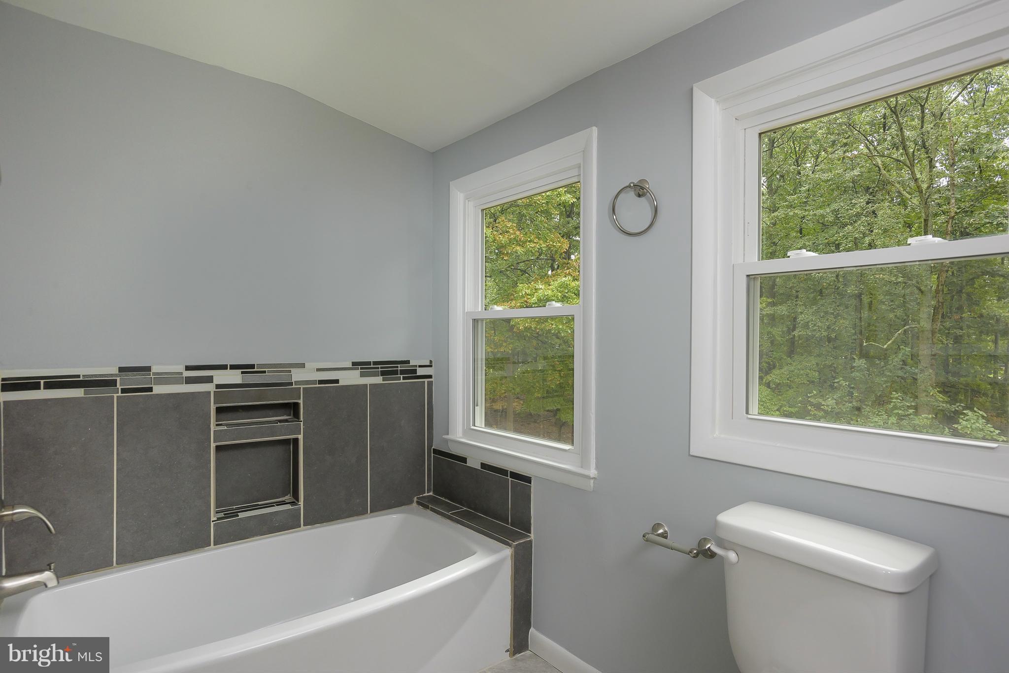 8413 Garland Road Pasadena, MD 21122 - Photo 16 of 30 a bathroom with a granite countertop sink a toilet and a bathtub