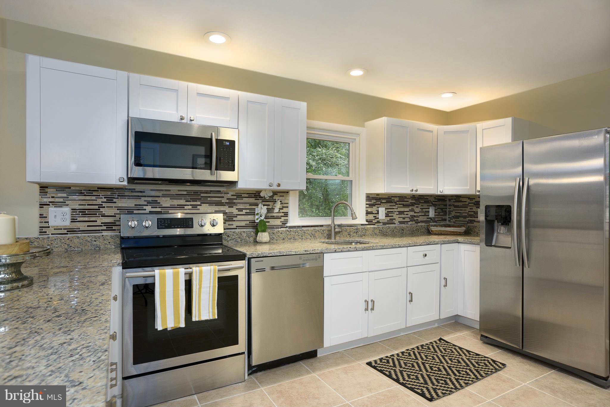 8413 Garland Road Pasadena, MD 21122 - Photo 9 of 30 a kitchen with granite countertop a stove sink and microwave