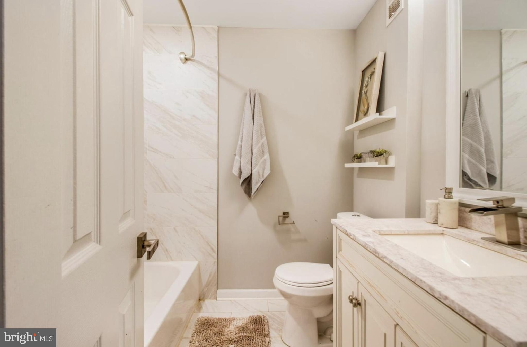 1149 Summit Street Northeast, Unit 2 Washington, DC 20002 - Photo 11 of 14 a bathroom with a granite countertop sink toilet and shower
