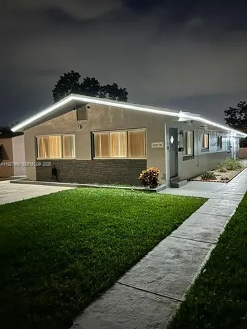 a front view of a house with a garden and plants
