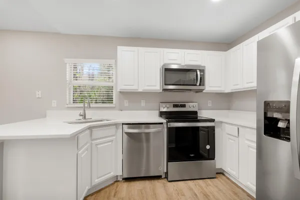 a kitchen with stainless steel appliances granite countertop a stove a sink and a microwave