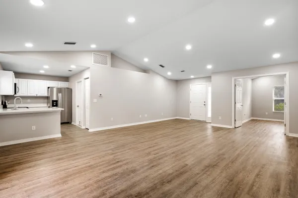 a view of kitchen with kitchen island granite countertop cabinets and wooden floor