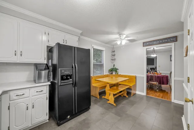a kitchen with stainless steel appliances white cabinets and stove top oven