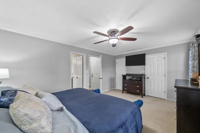 a bedroom with a bed a chandelier and a dresser