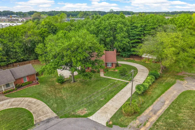 an aerial view of a house with a yard and lake view