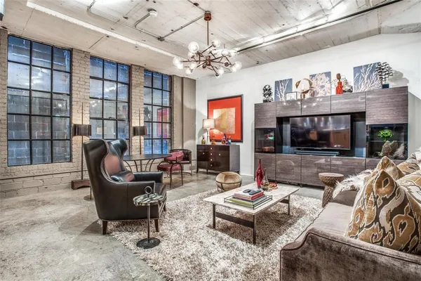 a living room with furniture a chandelier and a flat screen tv