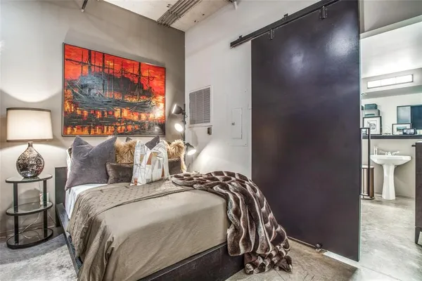 a bedroom with a bed and dresser with mirror