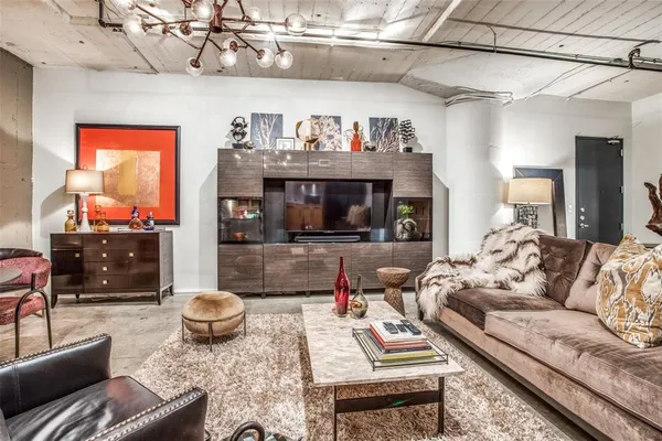 a living room with patio furniture and a chandelier