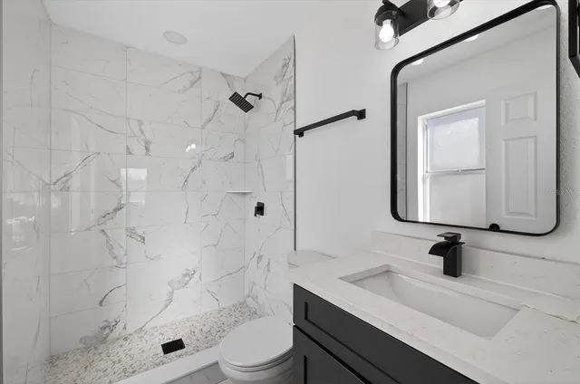 a bathroom with a sink toilet a mirror and shower