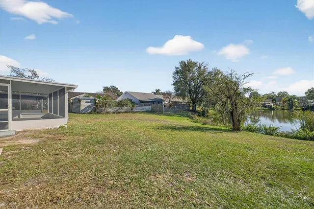 a view of a house with a yard and a pond