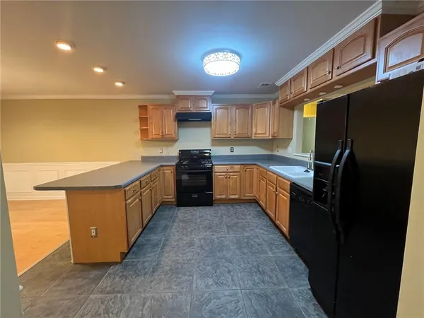 a kitchen with stainless steel appliances granite countertop a stove a sink dishwasher a refrigerator and a refrigerator
