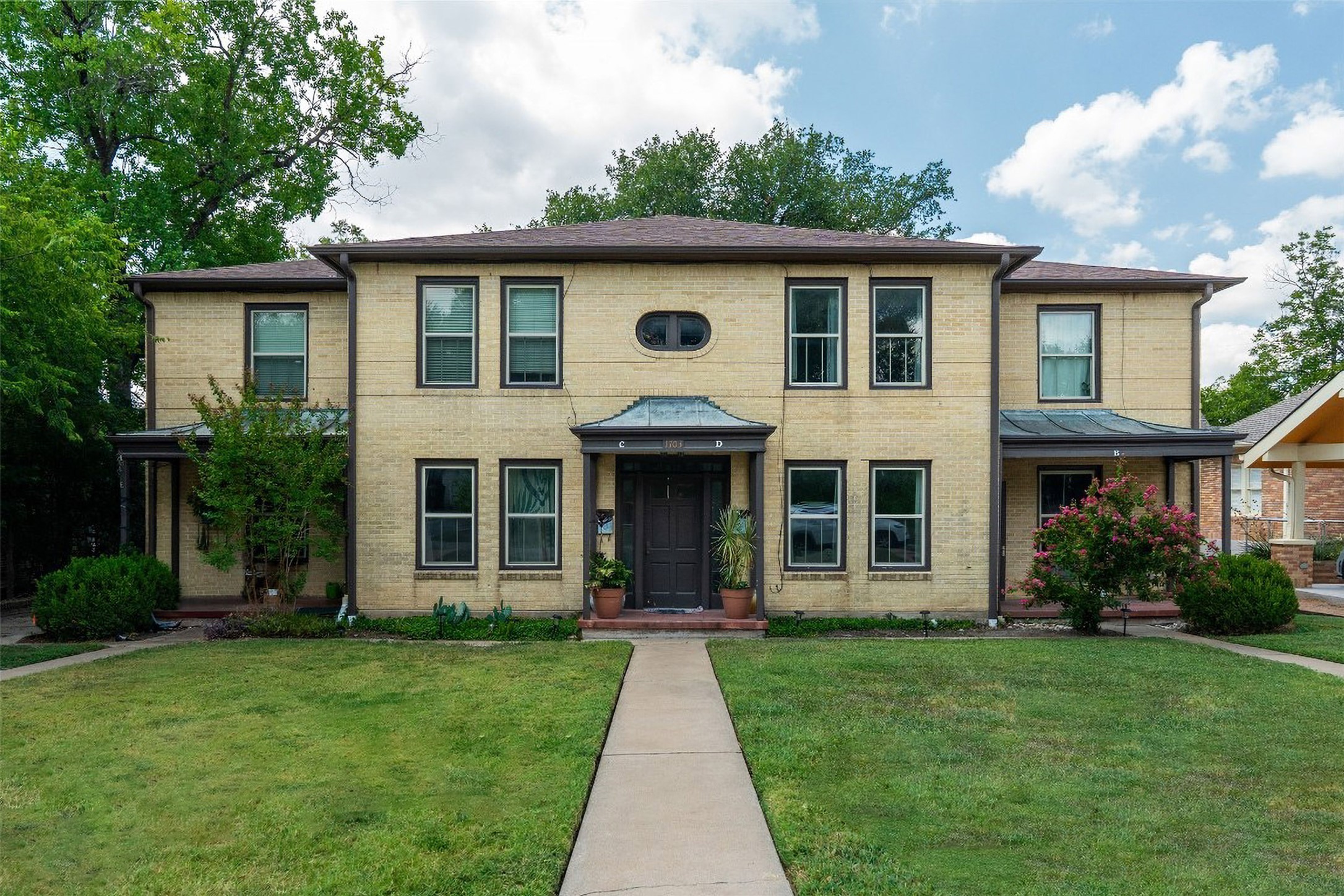 1703 Summit View Place, Unit A Austin, TX 78703 - Photo 11 of 13 Timeless brick residence featuring a classic facade and welcoming front entrance, framed by lush green lawns.