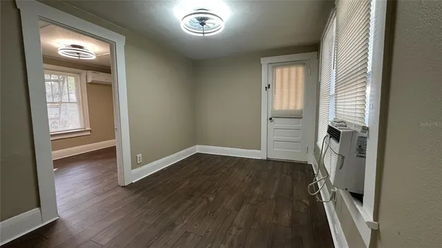 an entryway to room with wooden floor and workspace