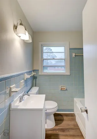 a bathroom with a sink a toilet and mirror