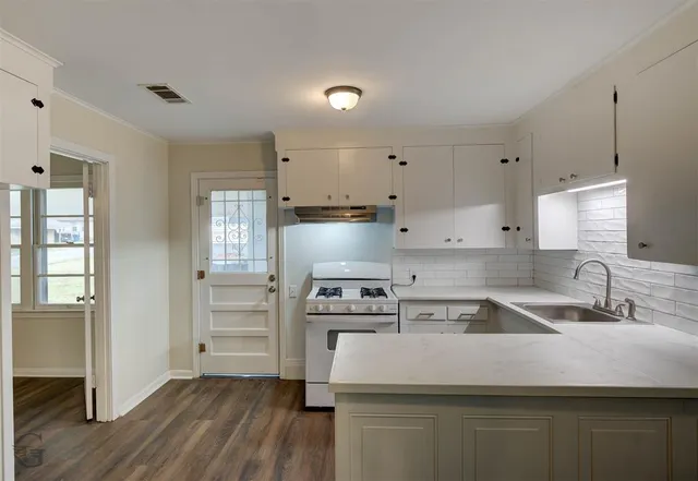 a kitchen with kitchen island white cabinets and stainless steel appliances