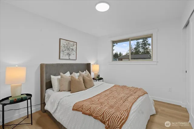 a bedroom with a bed and a lamp on dresser