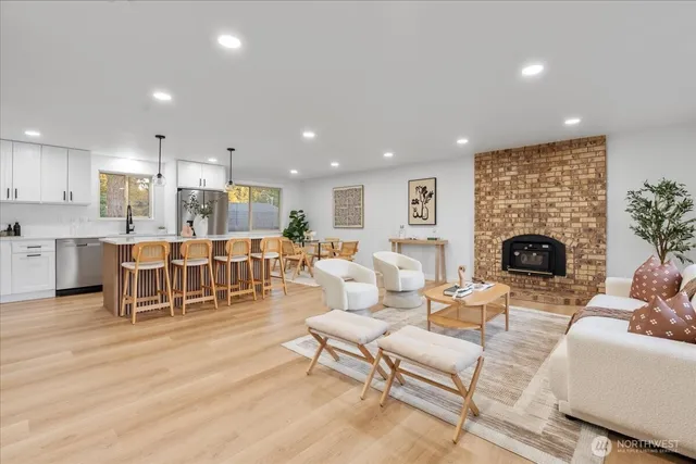 a living room with furniture a fireplace and a view of kitchen