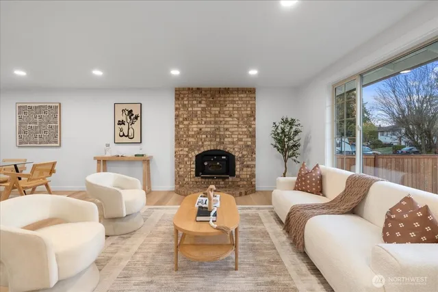 a living room with furniture fireplace and large windows
