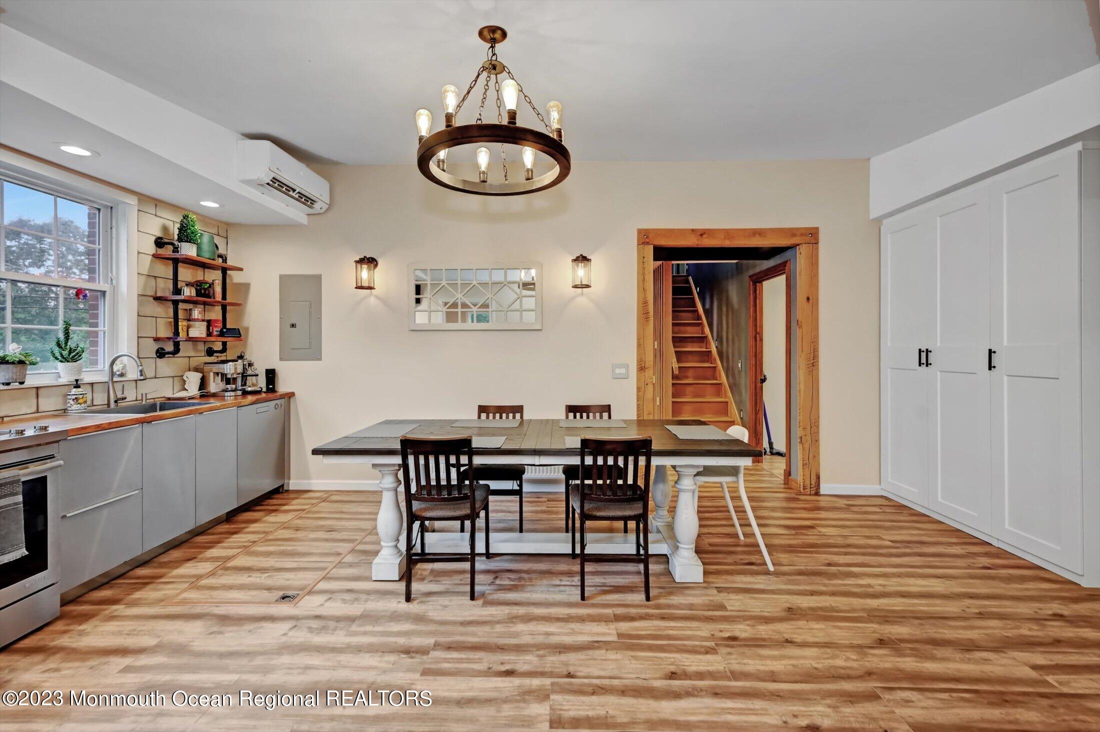 33 Conover Road Colts Neck, NJ 07722 - Photo 11 of 35 a dining room with wooden floor a chandelier a wooden table and chairs