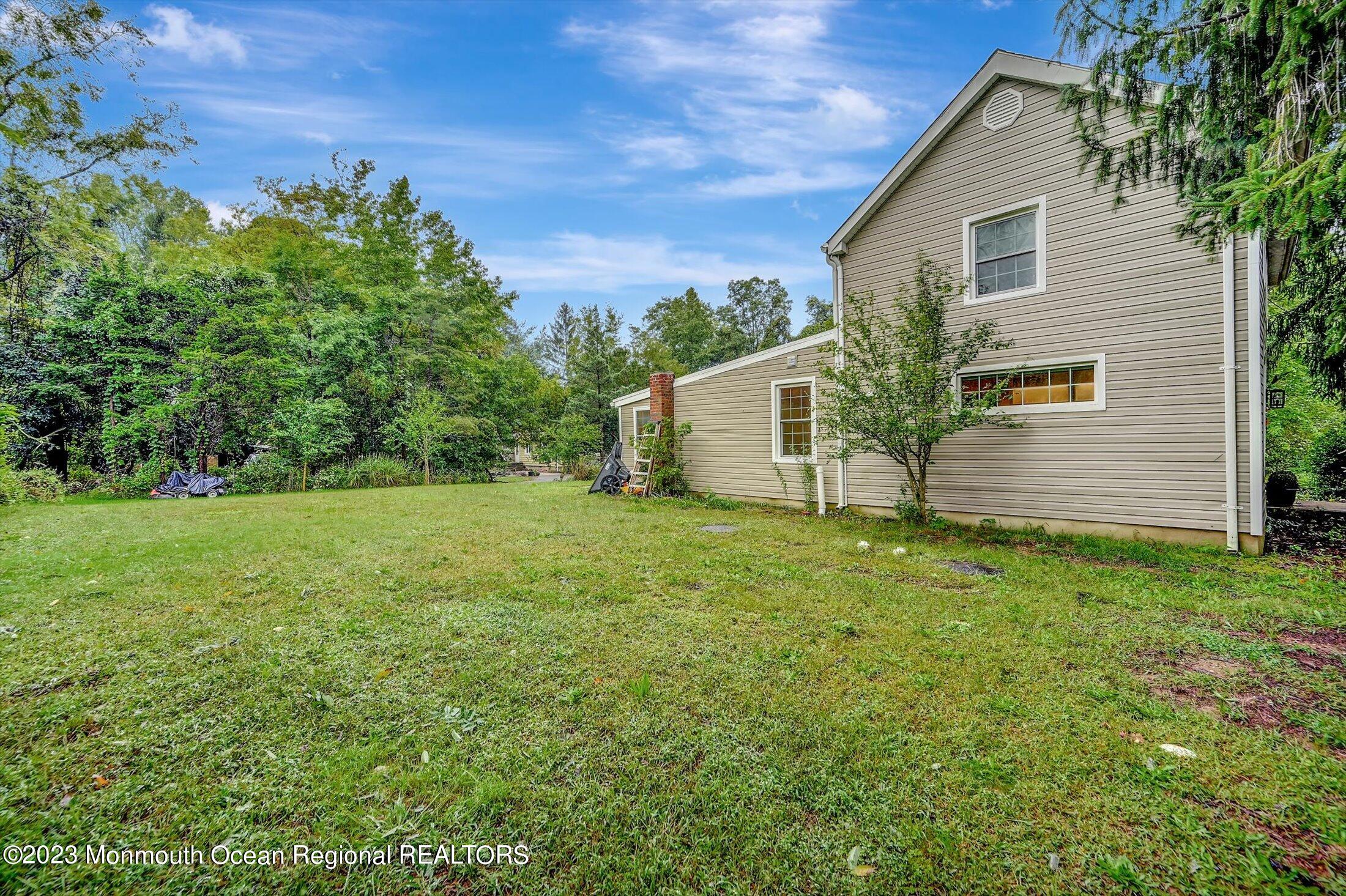 33 Conover Road Colts Neck, NJ 07722 - Photo 30 of 35 a backyard of a house with plants and large tree