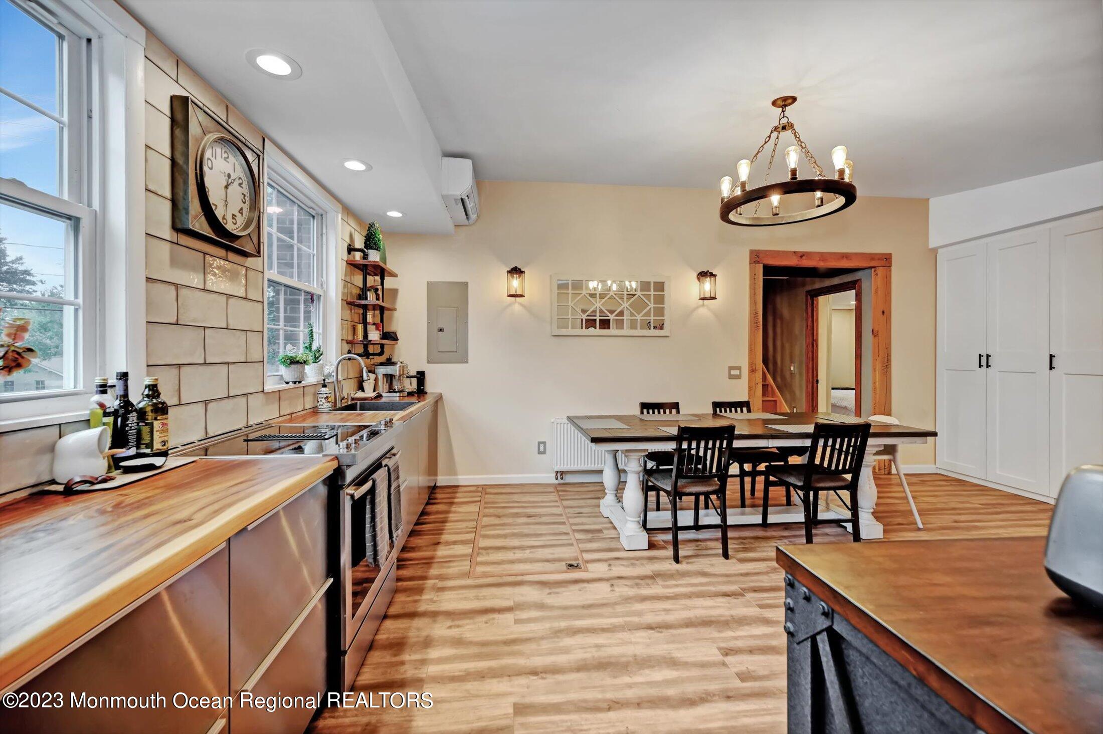 33 Conover Road Colts Neck, NJ 07722 - Photo 10 of 35 a kitchen with stainless steel appliances a dining table and chairs with wooden floor