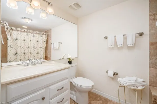 a living room with lots of chairs and kitchen view