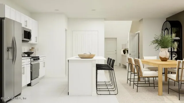 a kitchen with stainless steel appliances kitchen island granite countertop a refrigerator and a stove top oven