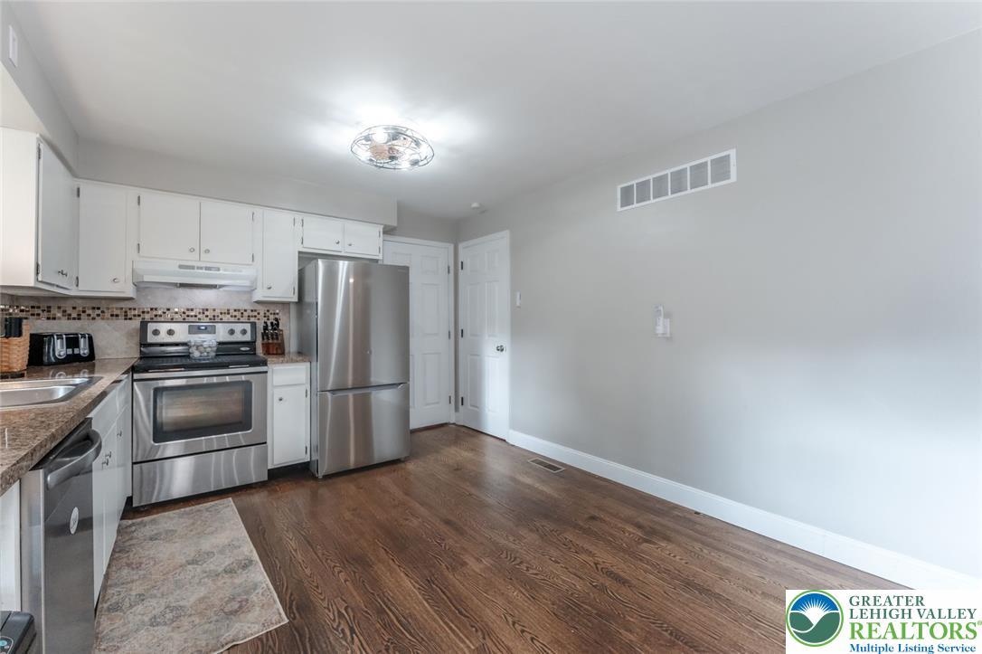 402 Maple Street Roseto, PA 18013 - Photo 10 of 39 Rich hardwood flooring anchors this updated kitchen featuring sleek stainless steel appliances.
