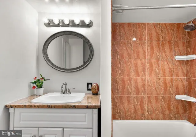a bathroom with a granite countertop sink and a mirror