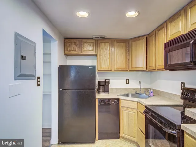 a kitchen with a refrigerator sink and cabinets