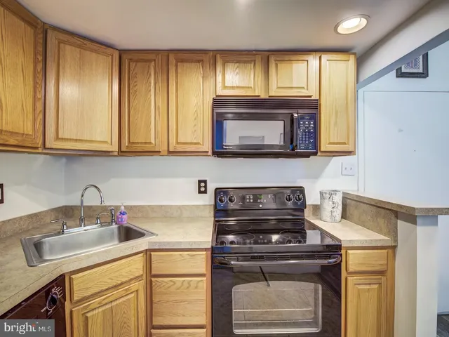 a kitchen with granite countertop cabinets stainless steel appliances and a window