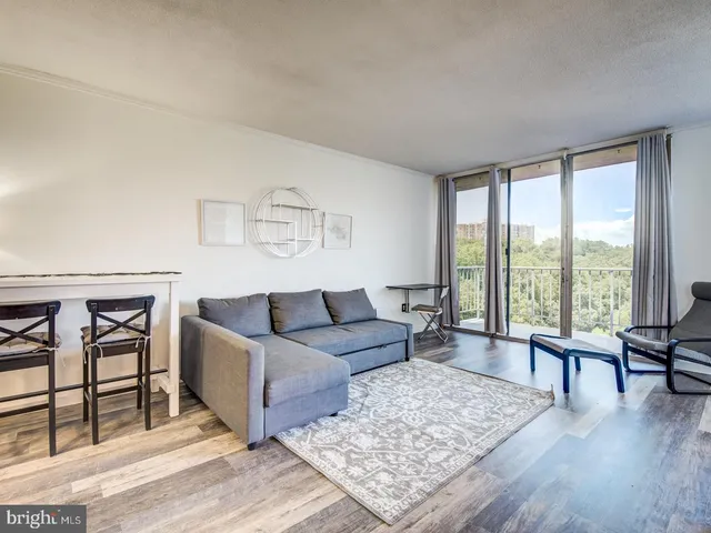 a living room with furniture and a floor to ceiling window