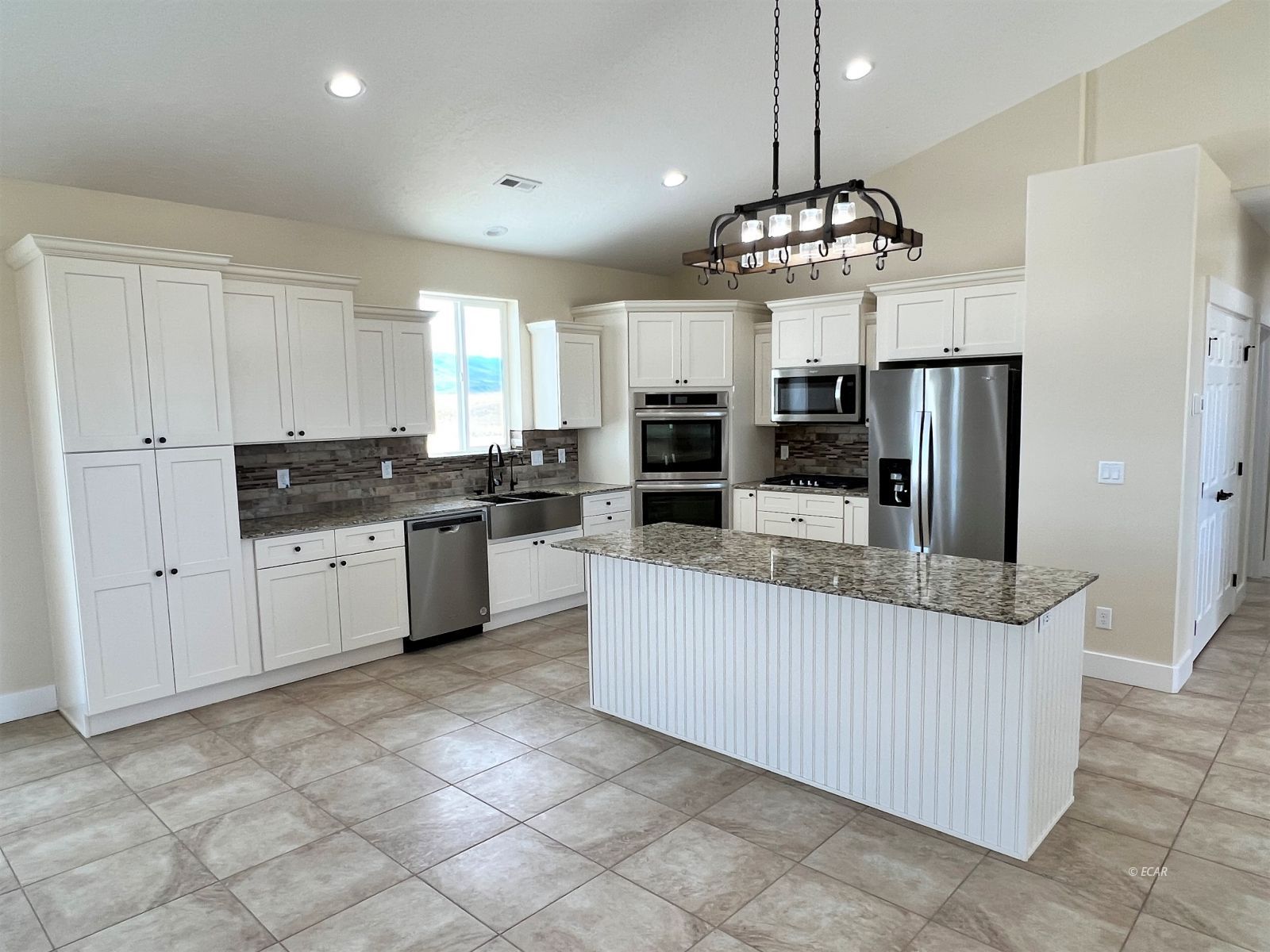 200 Ridgeway Drive Spring Creek, NV 89815 - Photo 2 of 34 a kitchen with granite countertop a refrigerator a sink dishwasher a oven and white cabinets
