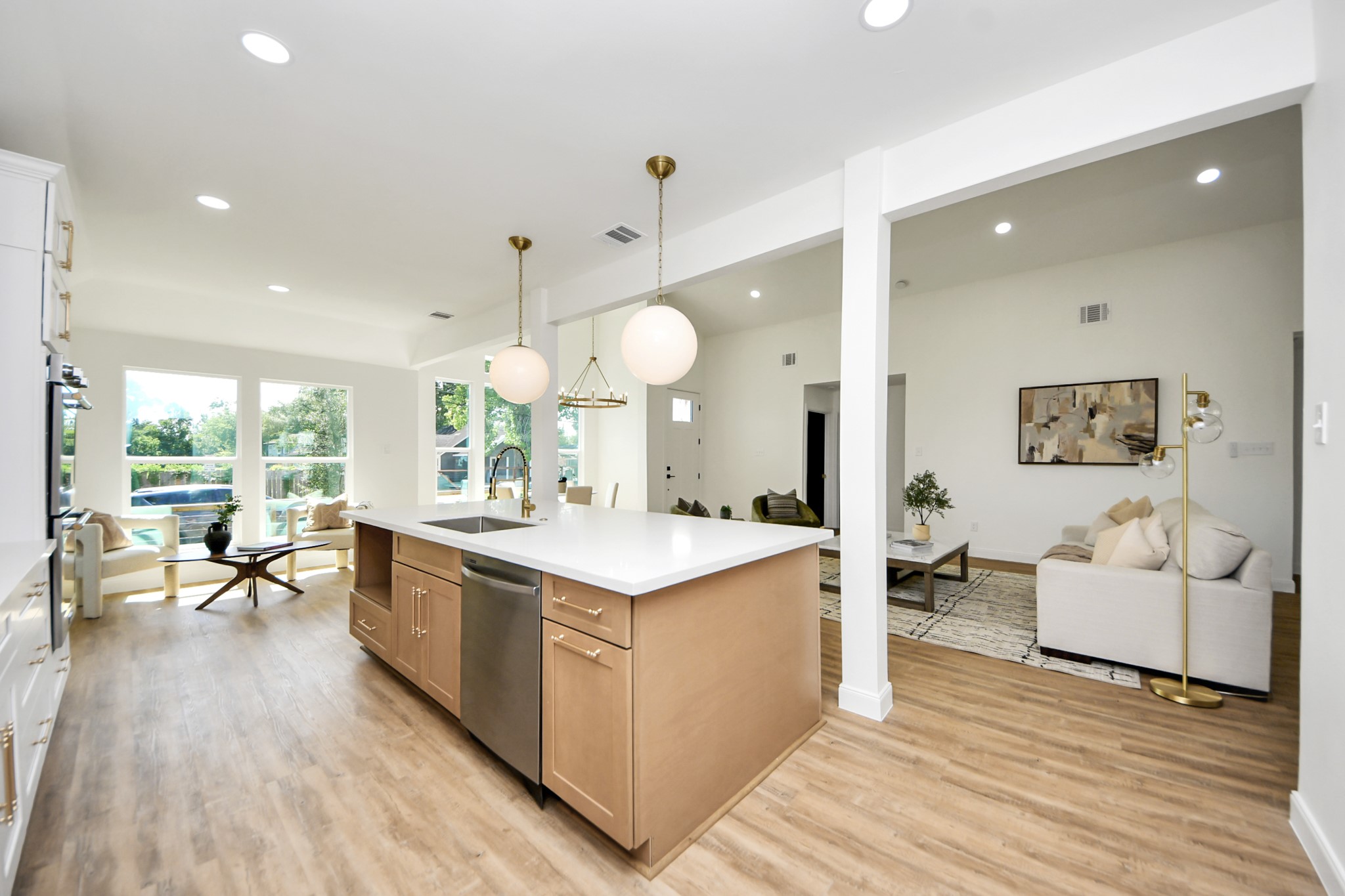1737 Tabor Street Houston, TX 77009 - Photo 12 of 44 This modern kitchen strikes the perfect balance between style and function. White cabinetry and stainless steel accents feel fresh and refined, while warm wood-like floors and pendant lighting add an inviting touch. The oversized island is more than just a workspace—it’s a natural gathering spot that flows effortlessly into the heart of the home.