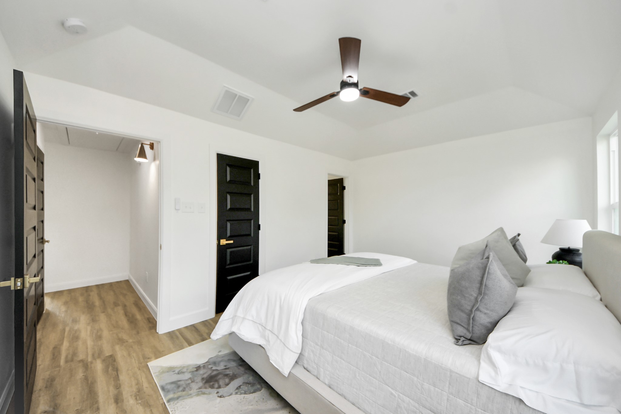 1737 Tabor Street Houston, TX 77009 - Photo 26 of 44 A serene, sunlit bedroom with vaulted ceilings that create an airy, restful retreat. Large windows invite in natural light, while neutral tones, a cozy bed, and simple, stylish touches complete the calm and inviting atmosphere.