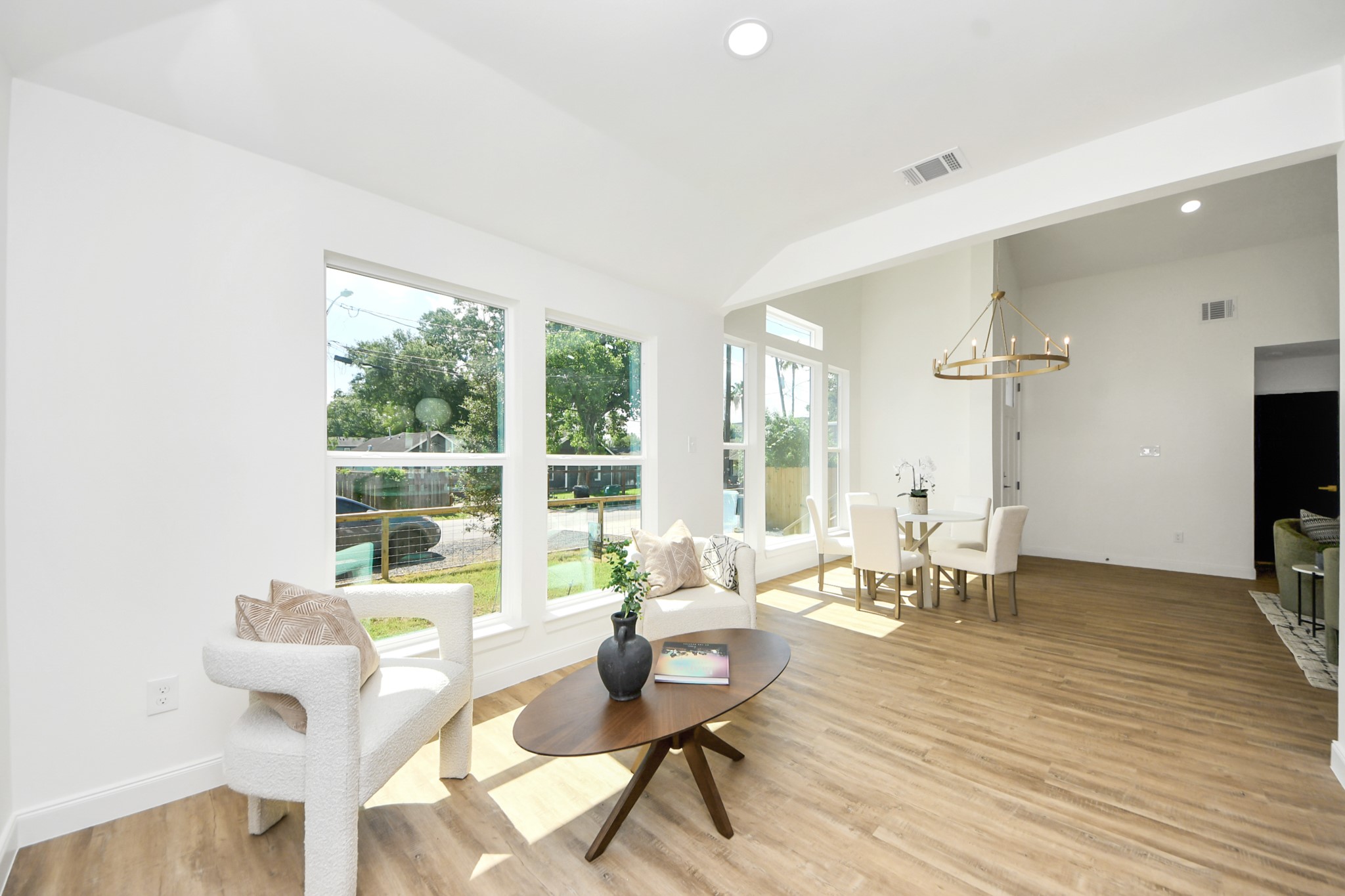 1737 Tabor Street Houston, TX 77009 - Photo 5 of 44 A sleek modern chandelier sets the tone for both casual dinners and special celebrations. Gather around the table as golden sunlight pours in through expansive window. The open layout flows effortlessly into a cozy sitting area—ideal for lingering conversations, entertaining guests, or enjoying quiet moments with family.