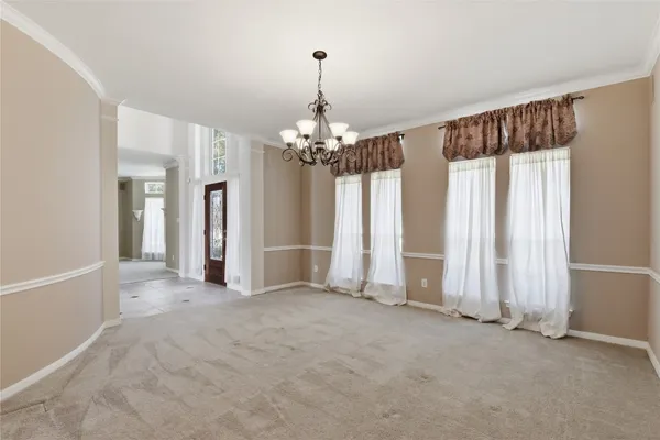 en empty room with chandelier and glass door