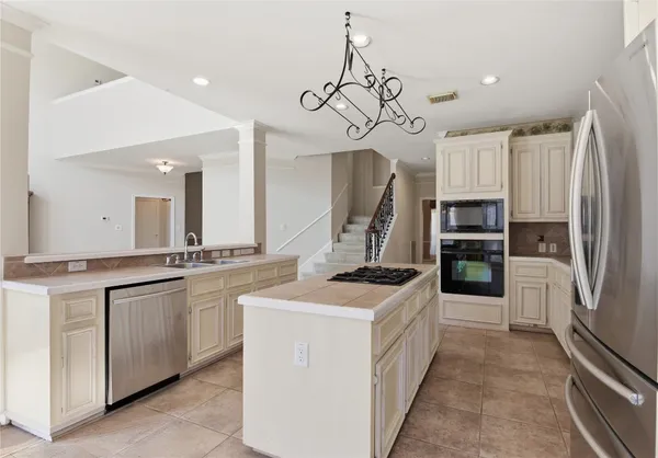 a kitchen with stainless steel appliances a stove a sink and a refrigerator