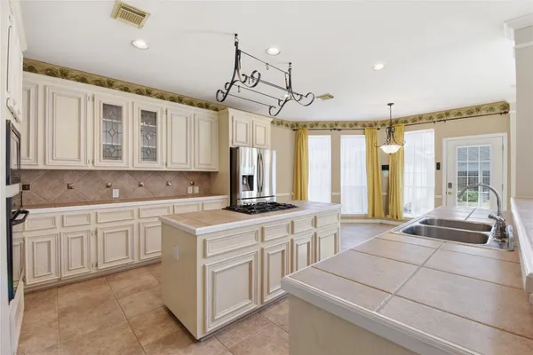 a kitchen with a stove a sink a refrigerator and wooden floor