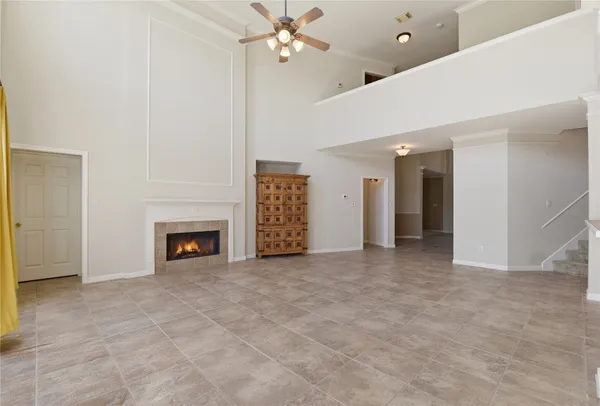 an empty room with windows and fireplace