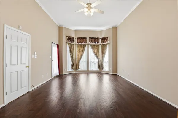 an empty room with wooden floor and window
