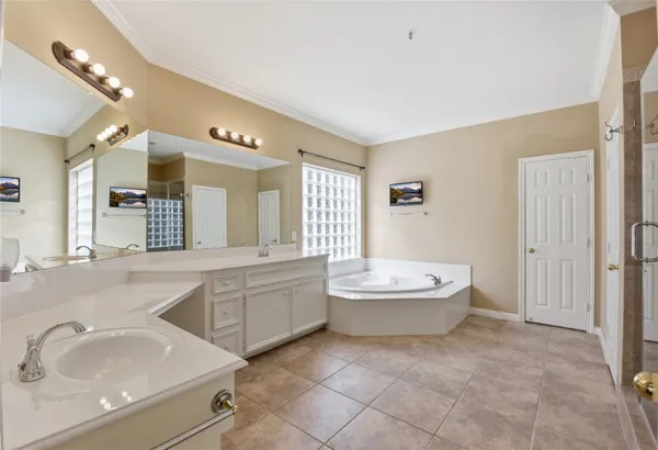 a spacious bathroom with a tub sink and mirror