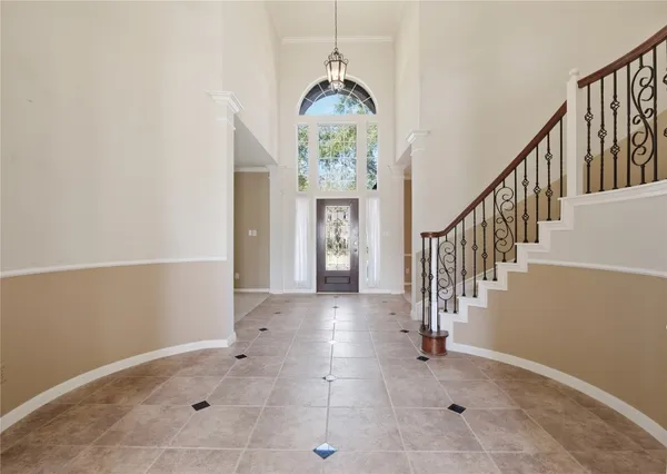 a view of entryway and hall with a chandelier fan