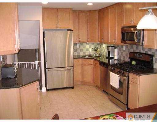 34 Baldwin Road Edison, NJ 08817 - Photo 3 of 8 a kitchen with granite countertop a refrigerator stove and microwave