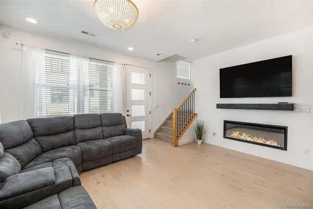 a living room with furniture a flat screen tv and a fireplace