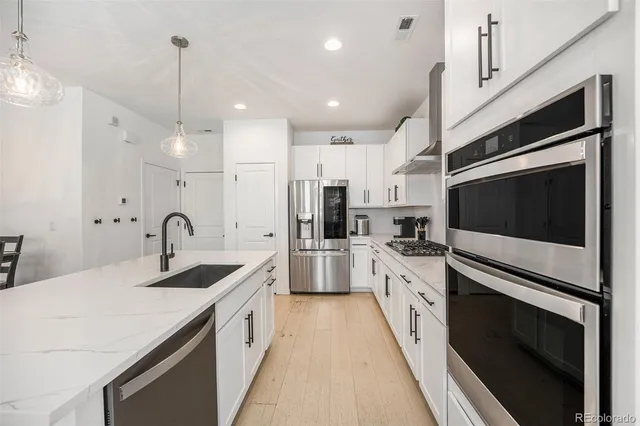 a large kitchen with stainless steel appliances kitchen island a large counter tops and a stove