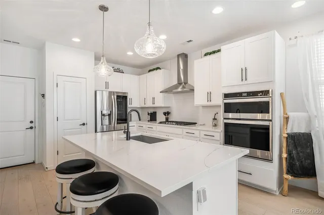 a kitchen with stainless steel appliances a stove a sink and a refrigerator