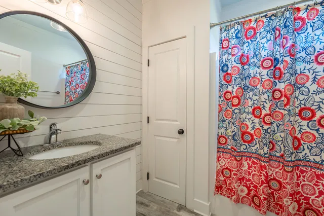 a bathroom with a granite countertop sink and a mirror