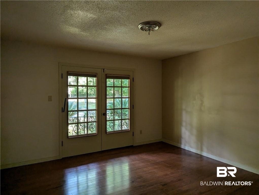 3608 Linden Lane Mobile, AL 36608 - Photo 7 of 20 Unfurnished room with wood-type flooring, french doors, and a textured ceiling